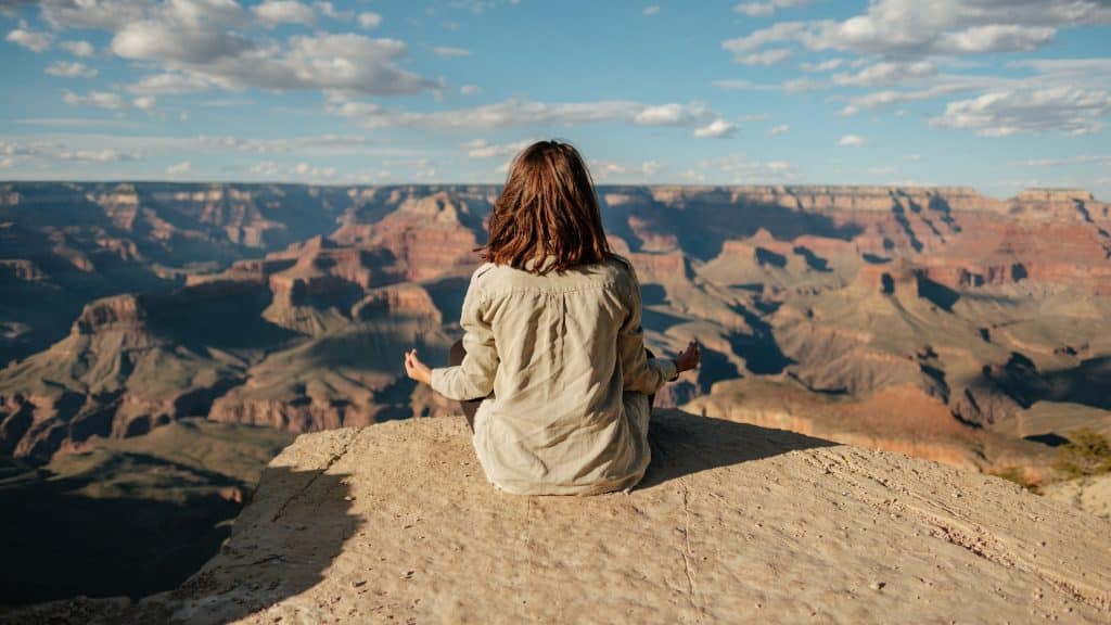 girl meditating on a cliff