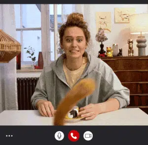 girl on a video call with her cat's tail in front of the web cam