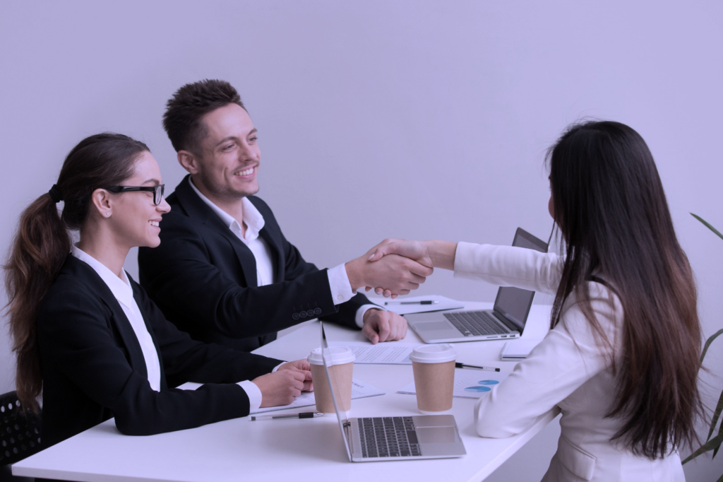 Personas entrevistando a un desarrollador de SaaS, dándose la mano en señal de acuerdo.