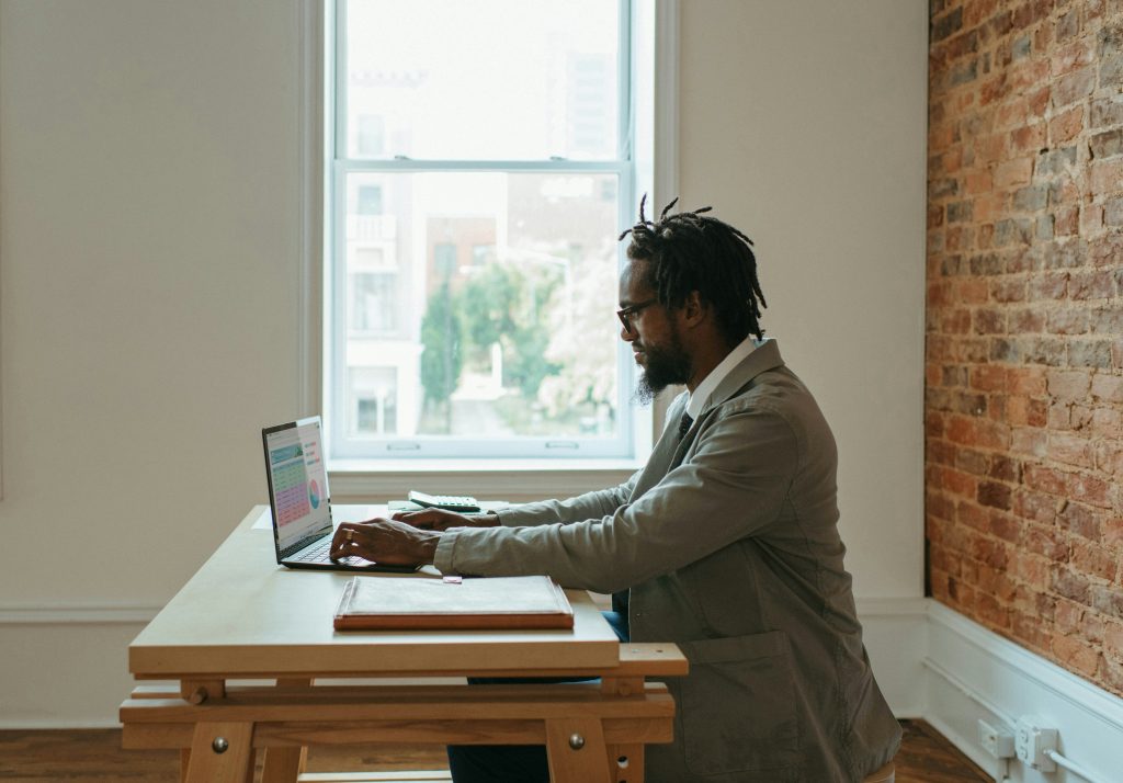 Um homem trabalhando remotamente demonstrando um formato popular de trabalho assíncrono.