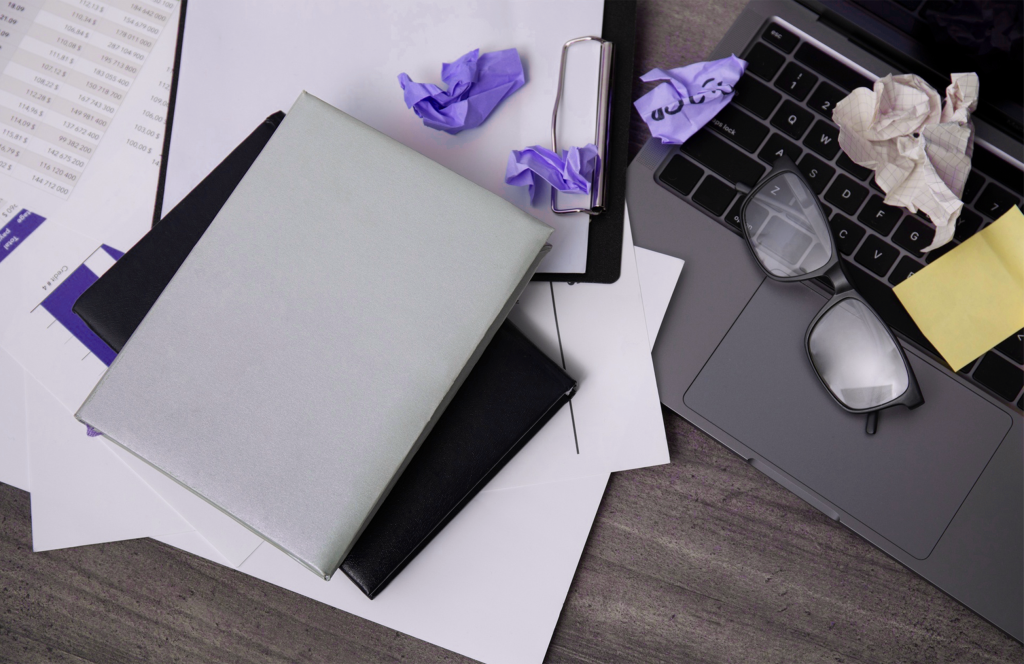 Uma visão de cima para baixo de uma mesa desordenada demonstrando o conceito de multitarefa humana