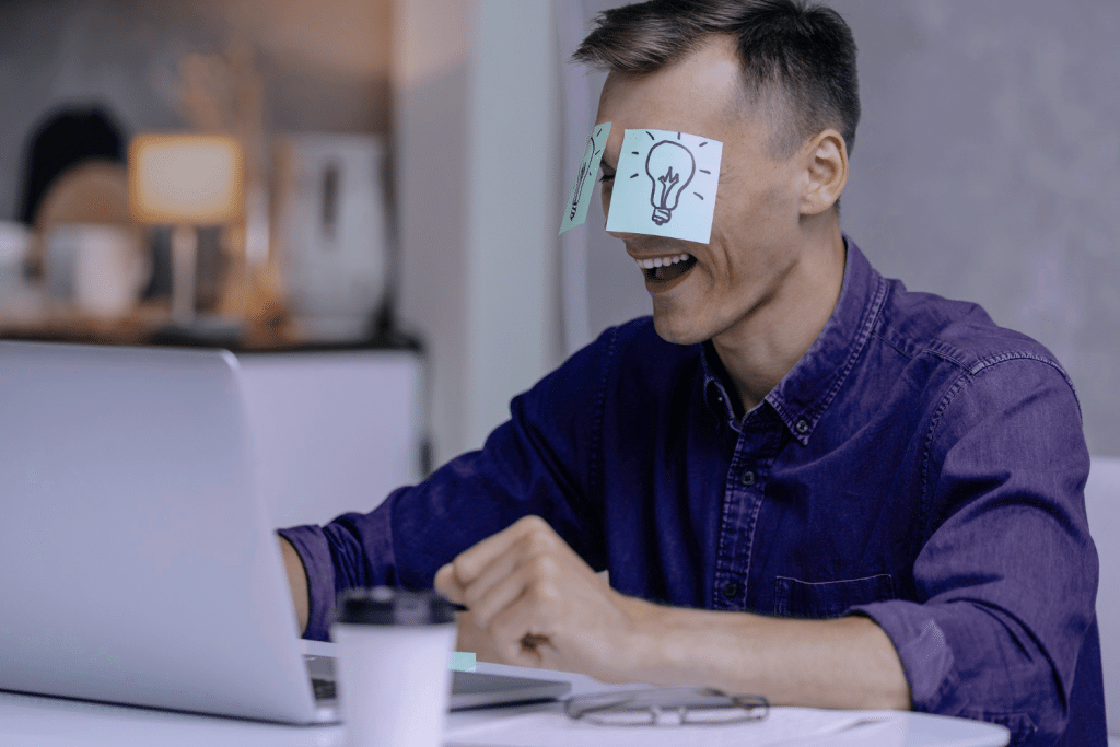 Uma pessoa com uma camisa roxa e dois post-its no rosto, simbolizando "truques de produtividade"
