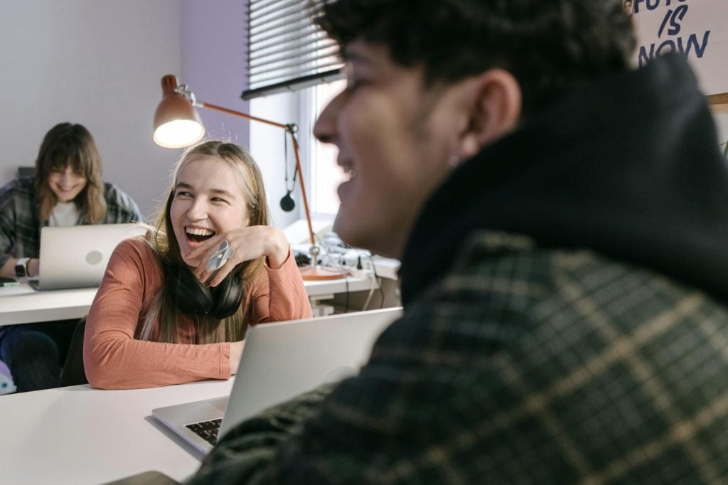 Adults collaborating and enjoying work in a shared office space, fostering creativity and connection.
