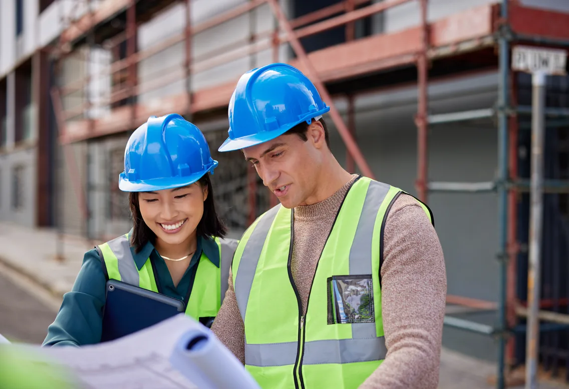 Equipo de construcción revisando planos del sitio mientras sus horas se rastrean con el seguimiento GPS de empleados de WebWork